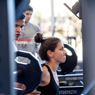Girl lifting weights at TCU rec center